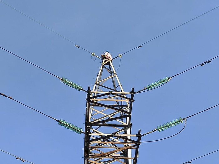 Nhiều người hốt hoảng khi thấy cô gái trên cột điện cao hàng chục mét. Ảnh: Dân Việt