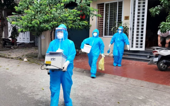 Cán bộ y tế lẫy mẫu xét nghiệm tại nhà những người liên quan 2 ca bệnh. Ảnh: Anh Chuyên/Tuổi Trẻ