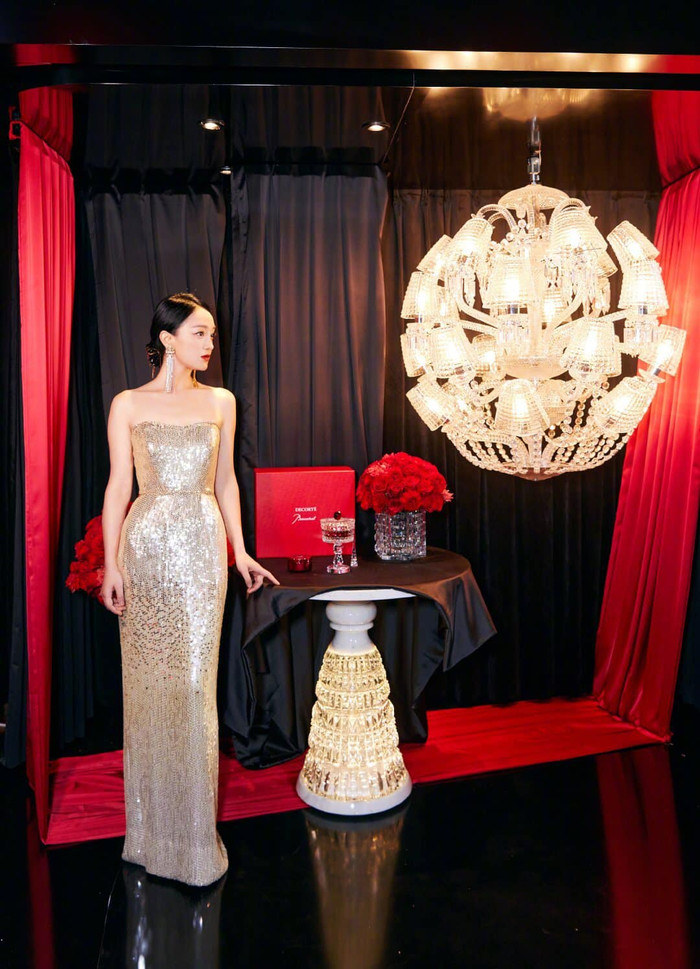 Tóc của cô được búi gọn gàng tô điểm thêm trang sức bông tai xuyệt tông óng ánh