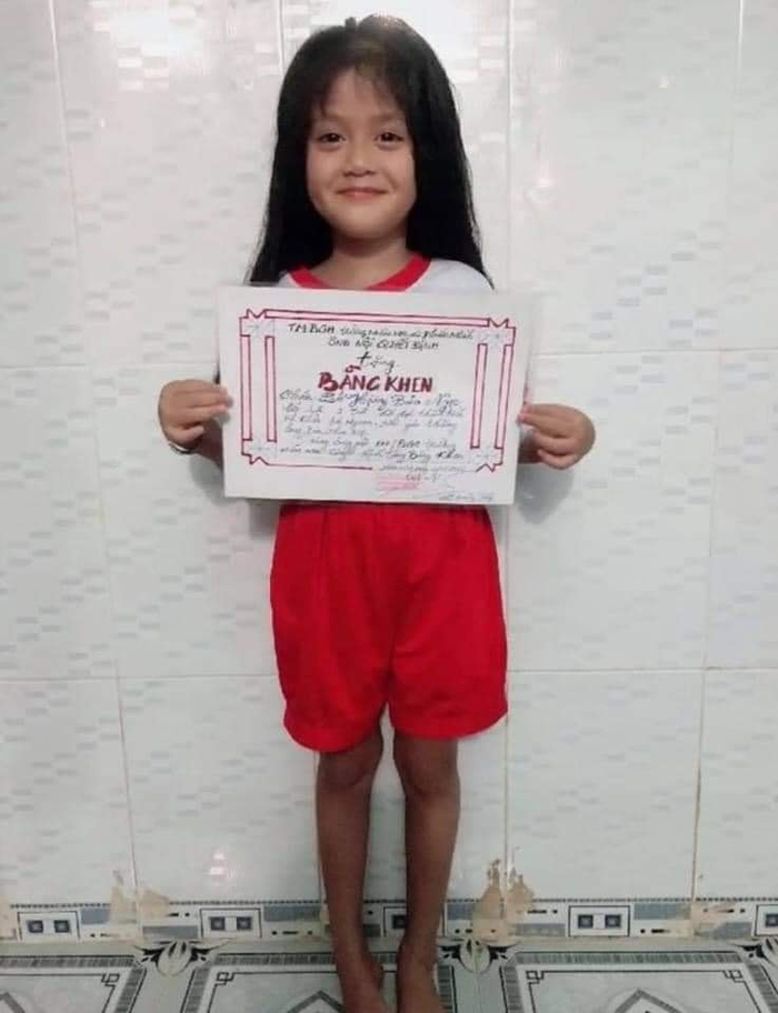 Nụ cười của cô cháu gái khi nhận được giấy khen từ ông nội