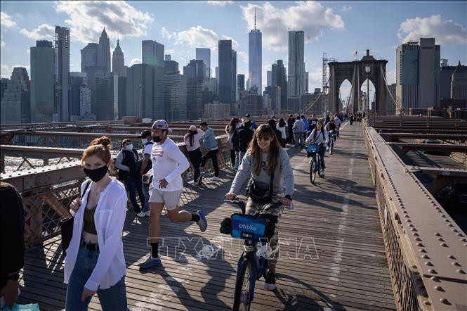 Người dân di chuyển trên cầu Brooklyn ở New York, Mỹ, ngày 25/4/2021. Ảnh: AFP/TTXVN