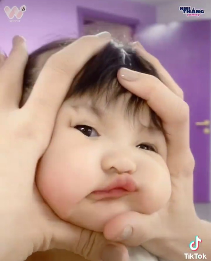 Nhìn biểu cảm miễn cưỡng của Winnie khi bị mẹ 'nhào nặn' cặp bánh bao khiến ai nhìn cũng bật cười.