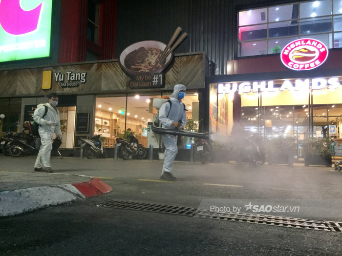 Các nhân viên y tế mặc đồ bảo hộ đầy đủ để phun khử khuẩn.