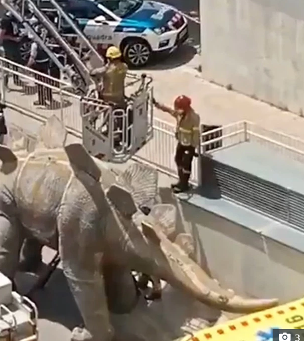 Lực lượng cứu hỏa phải dùng cần cẩu để đưa thi thể ra khỏi bức tượng khủng long.