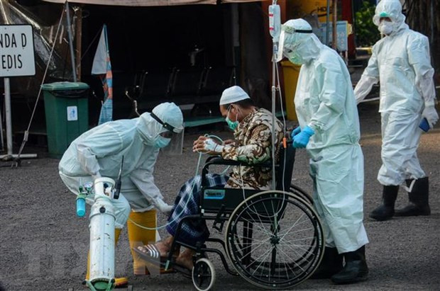 Nhân viên y tế chuyển bệnh nhân Covid-19 tới bệnh viện ở Surabaya, Đông Java, Indonesia. (Ảnh: THX/TTXVN)