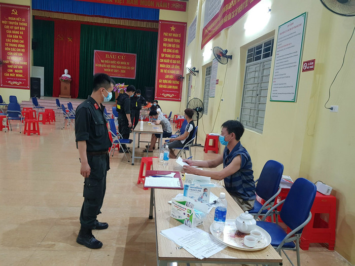 Nhóm người tụ tập uống bia, xem đá bóng được đưa về nhà văn hóa xã Tiền Phong làm việc. Ảnh Người Lao Động