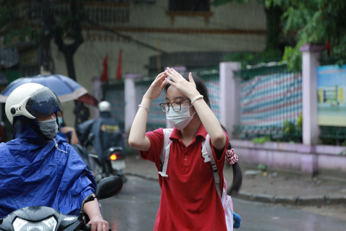 Mưa lớn khiến một số tuyến đường ngập nước khiến việc đến điểm thi của các em học sinh càng trở nên khó khăn hơn.