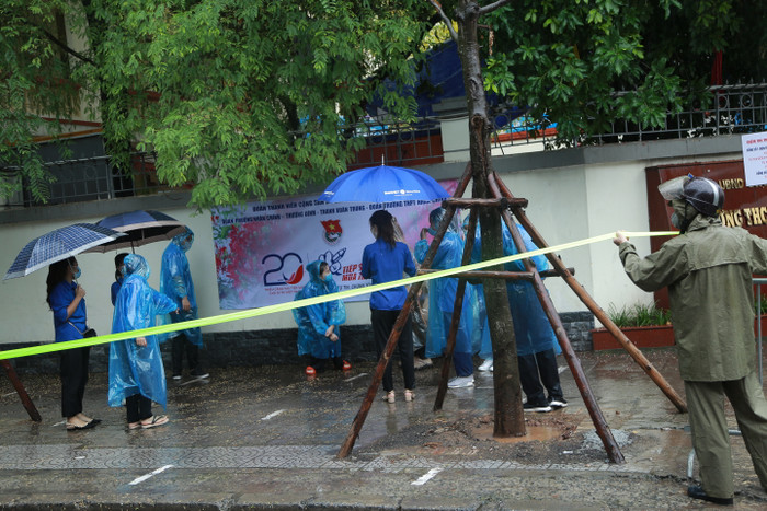 Các tình nguyện viên nghỉ giải lao sau hàng giờ hỗ trợ học sinh đi thi.