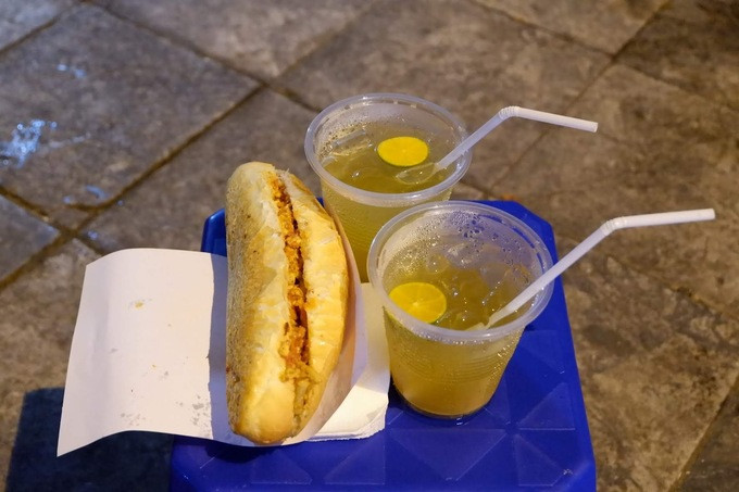Khi đi chơi đêm, du khách có thể thưởng thức bánh mì 'dân tổ' ở góc phố Trần Nhật Duật, Cao Thắng. Bánh mì có lớp vỏ giòn rụm với phần nhân trứng, patê, bơ, chả, lạp xưởng xào chung, ăn kèm dưa chuột và rau thơm. Ảnh: Lan Hương.