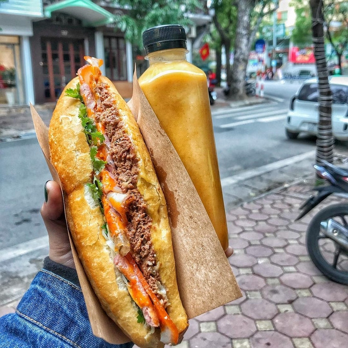 Ở Hà Nội, bánh mì là món ăn sáng phổ biến, hoặc là món ăn trưa khi muốn đổi vị. Bánh mì trước kia thường có nhân pate, giò lụa, ruốc, trứng rán, rau mùi và tương ớt. Ngày nay bánh mì có thêm nhiều loại nhân ăn kèm như thịt nướng, jambon, xá xíu hoặc chấm cùng bát sốt vang... Đặc trưng dễ thấy của bánh mì Hà Nội là không quá dày, vỏ bánh giòn xốp. Ảnh: Banhmibacan/Instagram.