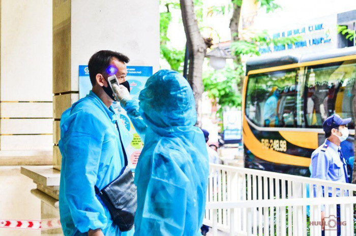 Nhân viên y tế tiến hành đo nhiệt độ cho các cầu thủ. Ảnh: Báo Giao Thông