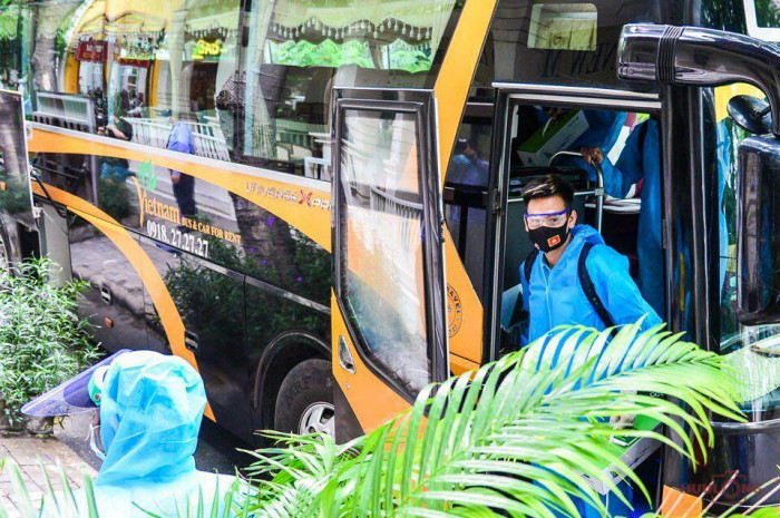 Các cầu thủ xuống xe để tiến vào khu cách ly. Ảnh: Báo Giao Thông