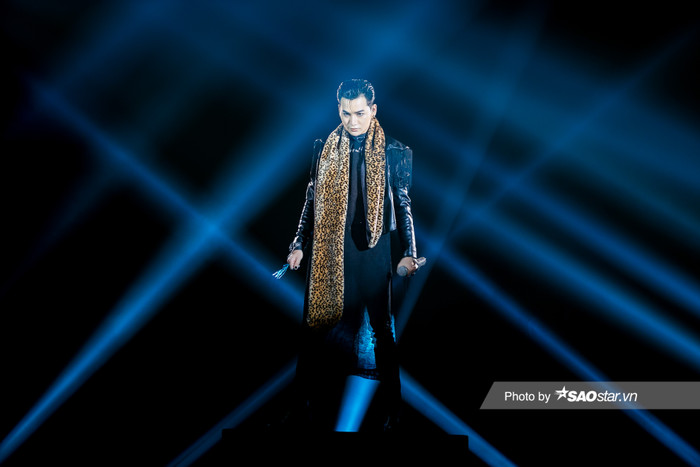 Nam ca sĩ diện cả set trang phục đen tuyền nhấn nhá phụ kiện khăn choàng cổ họa tiết da beo làm điểm nhấn