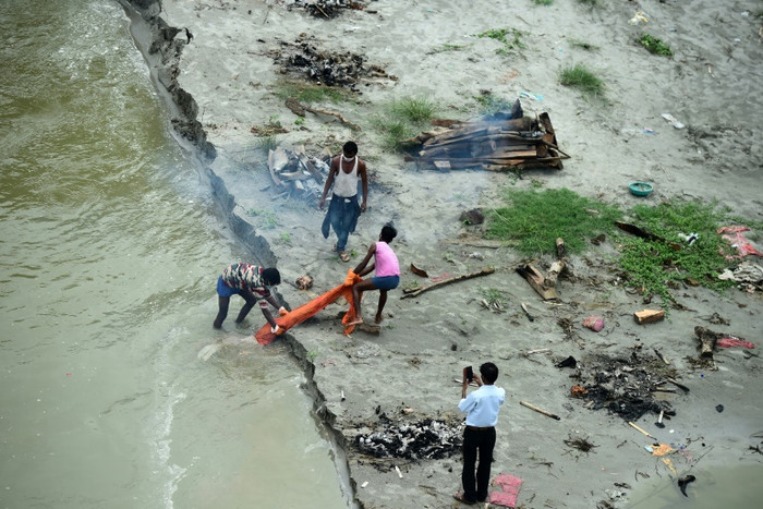 Nhiều thi thể chôn ven sông Hằng bị nước cuốn trôi khi mùa lũ tới. Ảnh: Reuters