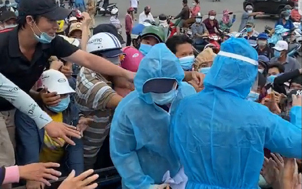 Người dân chen nhau lấy giấy ghi thông tin để xét nghiệm Covid-19 ở chợ Bình Điền. Ảnh: C.N/Facebook