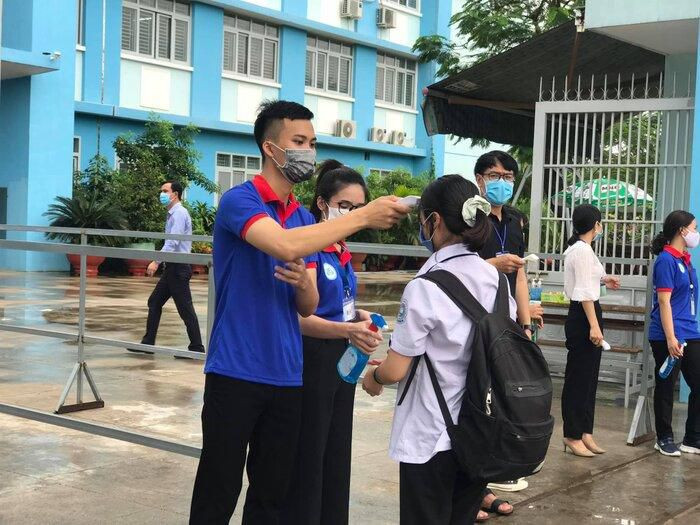 Các thí sinh đều chấp hành việc đeo khẩu trang y tế, được đội sinh viên tình nguyện tiến hành đo thân nhiệt, xịt khử khuẩn trước khi vào bên trong điểm thi.