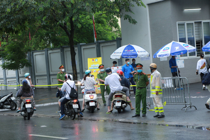 Tình nguyện viên và lực lượng giao thông có mặt để tổ chức phân luồng, đảm bảo an ninh trật tự trước điểm thi