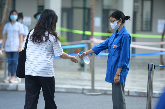 Các sĩ tử sẽ được đo thân nhiệt, xịt sát khuẩn trước khi vào bên trong điểm thi