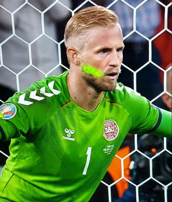 Kasper Schmeichel bị chiếu laser vào mặt ở tình huốn đối đầu Kane trong quả phạt đền phút 102.