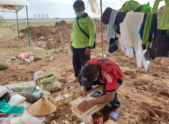 Darsiman đang đợi thợ khắc chữ viết tên người chết vì Covid-19 trên bia mộ.