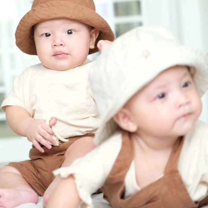 Lần khác, gia đình cho 2 bé đội 2 chiếc nón giống hệt nhau, chỉ khác màu. Thoạt nhìn là thấy rõ hai anh em sinh đôi.