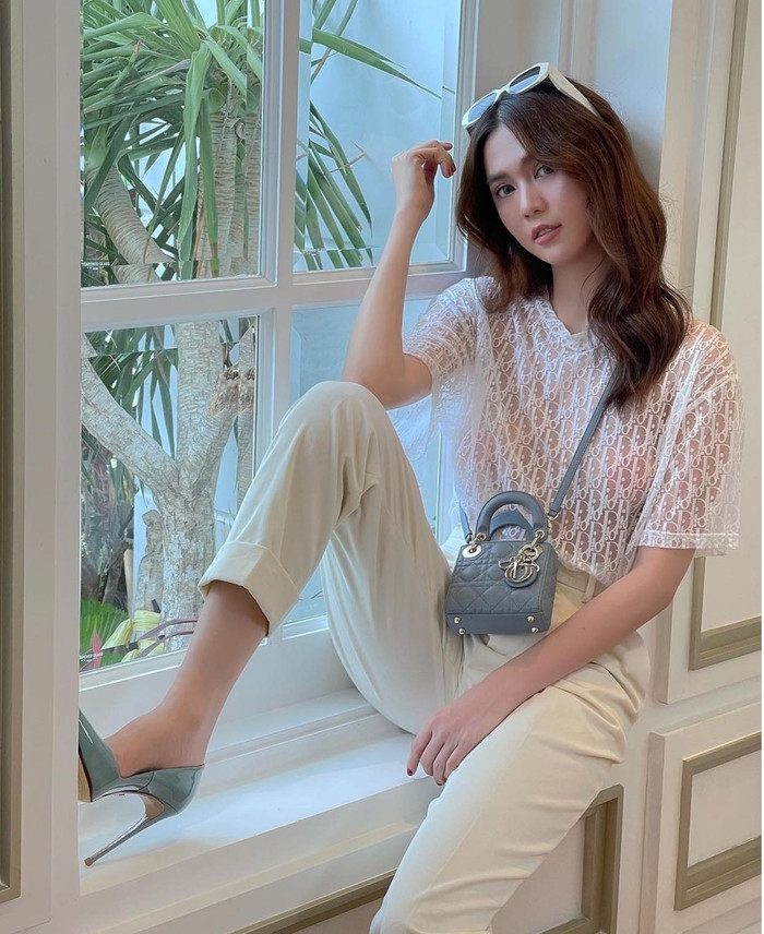 Mỹ nhân gốc Trà Vinh lên đồ kín đáo thanh tao với áo thun trắng xuyên thấu độc đáo mix cùng quần âu kết hợp túi xách micro nhỏ bé