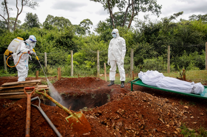 Thành viên của một nhóm chuyên mai táng các bệnh nhân Hồi giáo chết vì Covid-19 phun thuốc khử trùng vào mộ trước khi chôn cất.