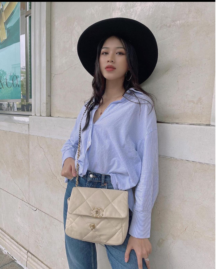 Người đẹp kết hợp với phụ kiện mũ vành đen và túi xách Chanel hàng hiệu màu be