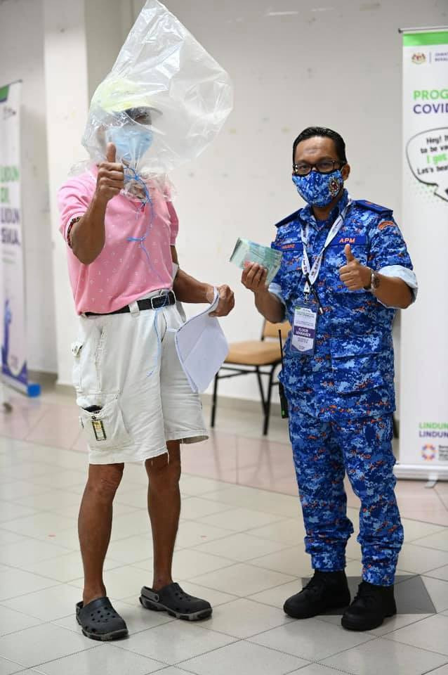 Ông chú trao một khoản tiền cho các nhân viên y tế.