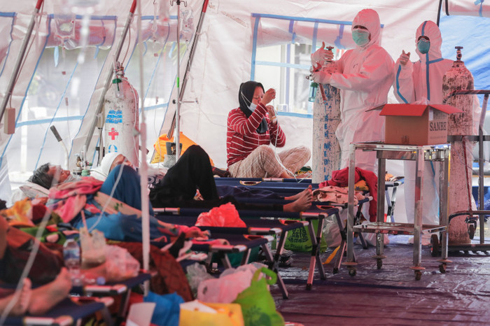 Nhân viên y tế kiểm tra bình oxy cho bệnh nhân nhiễm Covid-19 bên trong lều dựng trước một bệnh viện ở Bekasi, gần Jakarta.