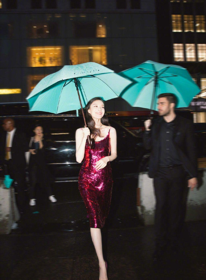 Nghê Ni nổi bần bật trong bộ váy sequin hai dây lấp lánh, tay cầm ô màu xanh ngọc khi tham dự một sự kiện thời trang ở nước ngoài cách đây vài năm trước