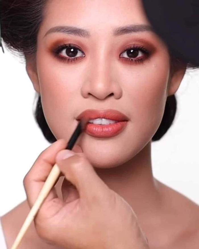 Chọn màu môi cam đỏ, tiệp với lối trang điểm mắt.