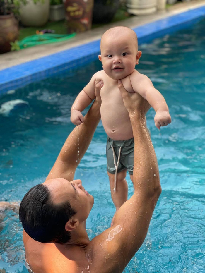Cậu nhóc cũng rất thích tắm hồ bơi, nghịch nước cùng với ba.