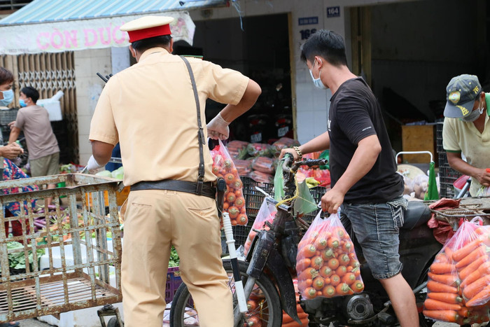 Lực lượng CSGT làm nhiệm vụ hỗ trợ người dân tại khu vực phong tỏa chợ đầu mối Tân An, TP Cần Thơ. Ảnh: Phạm Đỗ Minh Trung