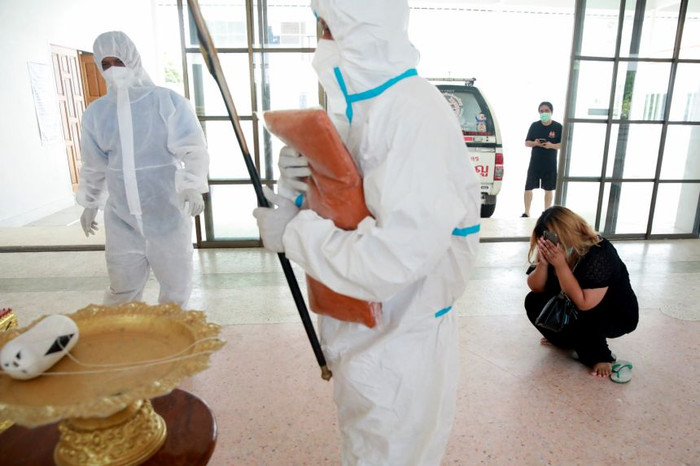 Một người phụ nữ ôm mặt khóc khi tiễn biệt người thân.