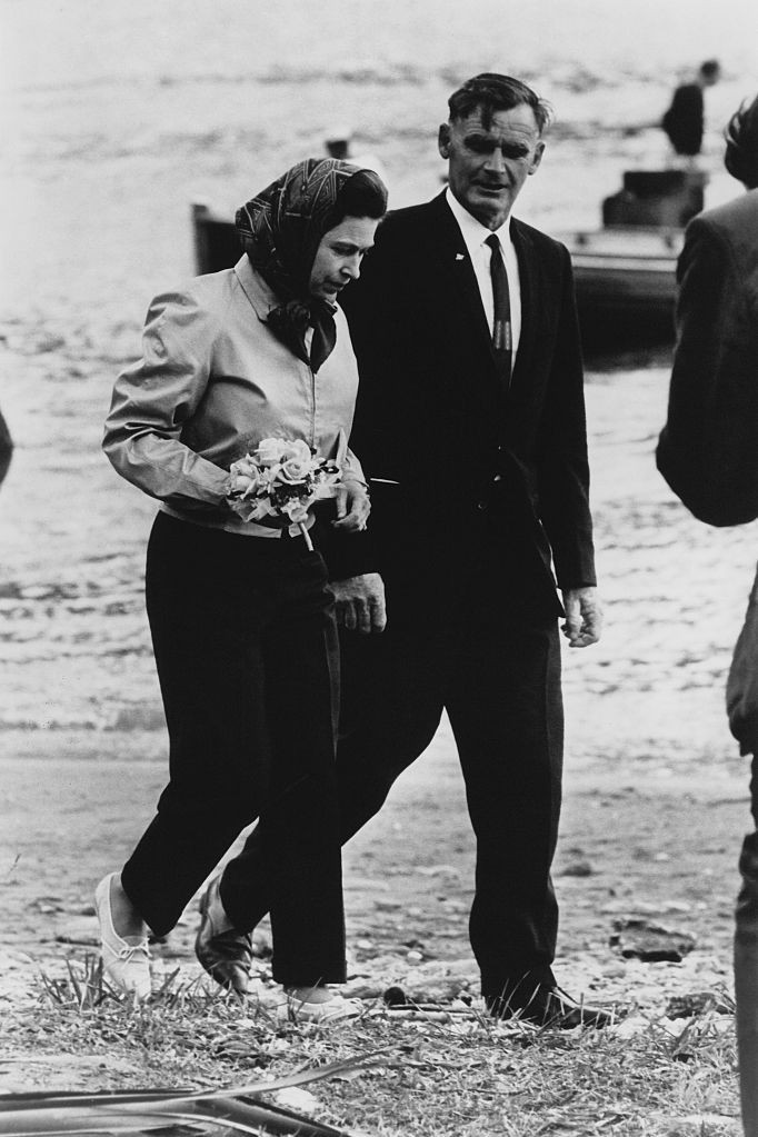 Bức ảnh này được chụp lúc Nữ hoàng Elizabeth rời khỏi Britannia (du thuyền hoàng gia) trong chuyến công du tới New Zealand. Bà đội chiếc khăn trùm đầu quen thuộc và đi một đôi giày trắng giản dị để tản bộ trên bãi biển Ship Cove.