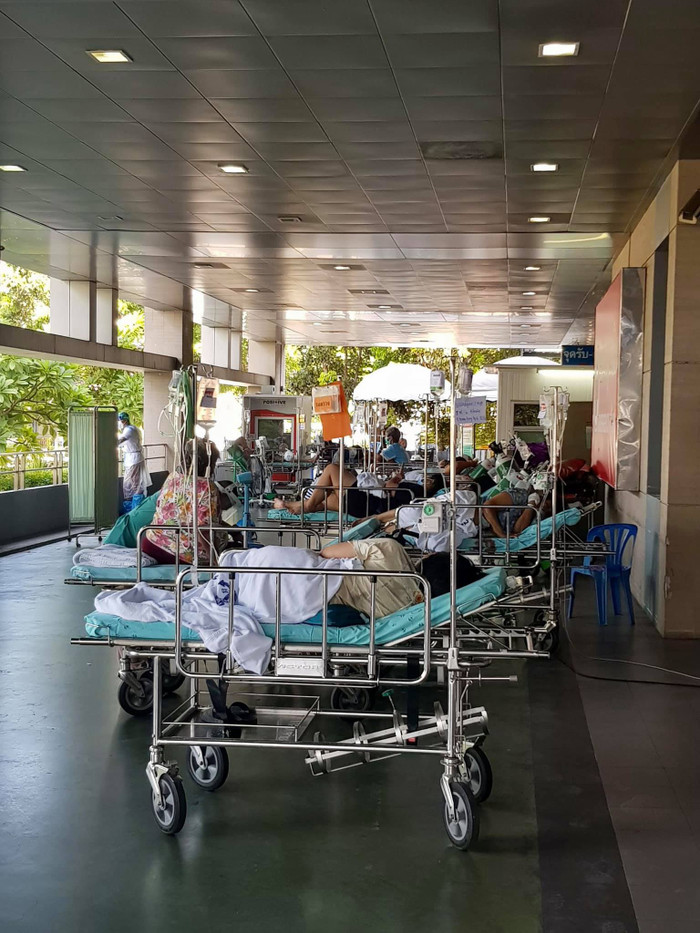 Một số bệnh nhân nghiêm trọng được cấp giường, nằm trước sảnh bệnh viện.