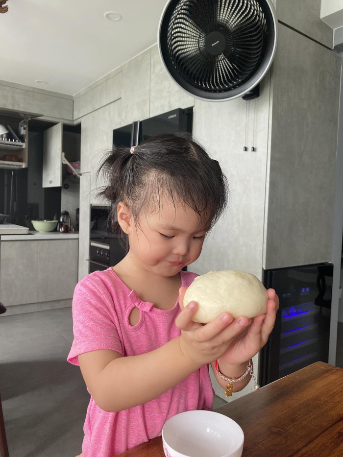 Lúc đầu, bé Bông rất chăm chú phụ mẹ nhào bột.