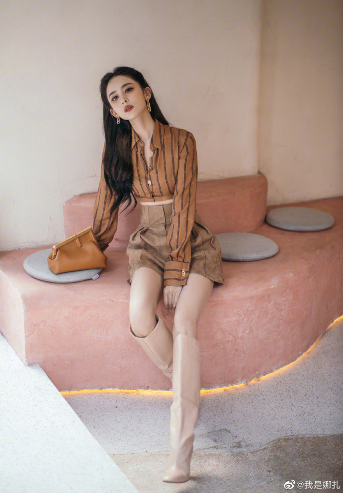 Với tông cam đất và màu be là gam chủ đạo, người đẹp kết hợp áo sơ mi crotop kẻ sọc mix cùng quần cạp cao và clutch cầm tay