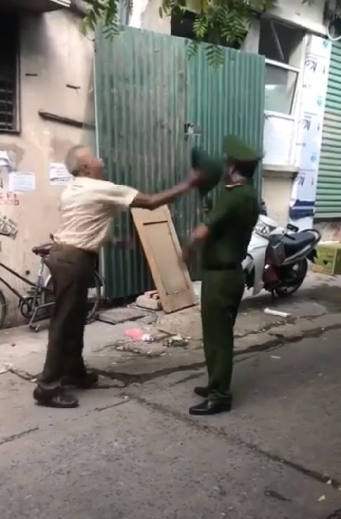 Cụ ông bất ngờ cầm mũ cối đánh mạnh vào đầu chiến sĩ công an.