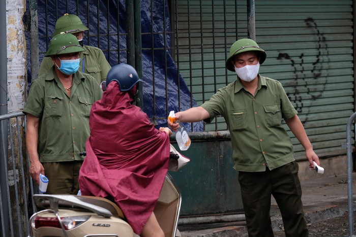 Những người vào chợ được đo nhiệt độ và rửa tay sát khuẩn. 