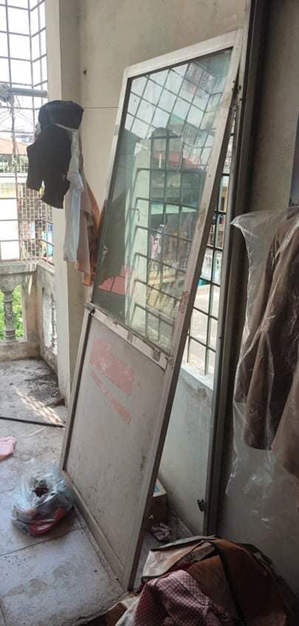 Cánh cửa bị bung cả ra được đặt tạm cạnh đó. 