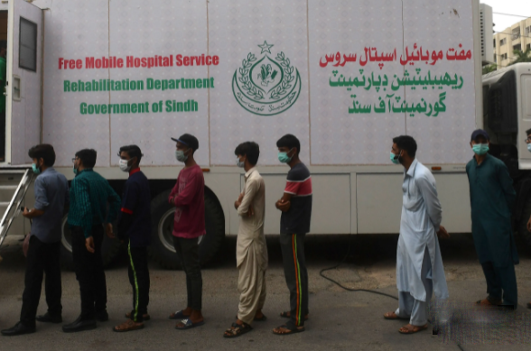 Dòng người xếp hàng chờ được tiêm vaccine Covid-19 bên ngoài một xe tải tiêm chủng di động ở Karachi, Pakistan vào ngày 4/8.