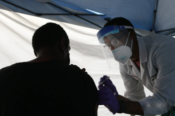 Bác sĩ Bonzo Reddick tiêm vaccine Covid-19 Johnson & Johnson cho bệnh nhân trong một phòng khám tại The Salvation Army.