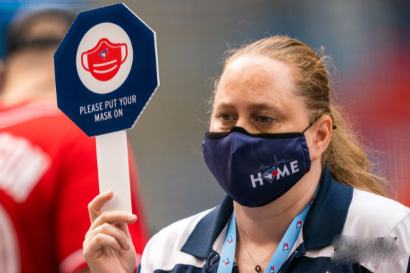 Một nhân viên của Toronto Blue Jays giơ biển nhắc nhở người hâm mộ đeo khẩu trang tại Trung tâm Rogers, ngày 31/7 ở Toronto, Ontario, Canada.