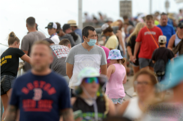 Một người đàn ông đeo khẩu trang khi đi dọc Bến tàu Đảo Okaloosa, ngày 19/7, gần Bãi biển Fort Walton, Florida, Mỹ. 