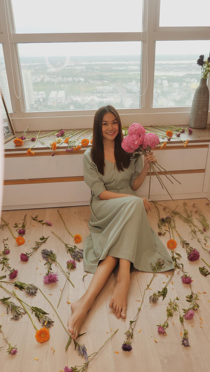 Đôi khi siêu mẫu hàng đầu Việt Nam còn đổi layout sang trang phục váy vóc bánh bèo nữ tính ở nhà cắm hoa 