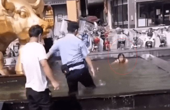 Cô gái phớt lờ khi cảnh sát yêu cầu ra khỏi hồ phun nước. 