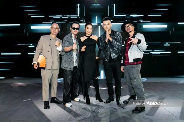 Trang phục all black quyến rũ với phần cut-out khoe khéo xương quai xanh của MC Phí Linh. Cô nổi bần bật khi đứng bên cạnh các vị master trong chương trình 