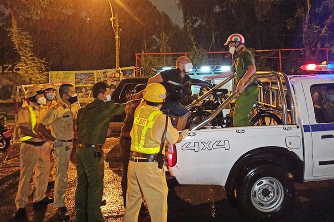 Người đàn ông bị cảnh sát khống chế đưa lên xe chuyên dụng. Ảnh: A.H/Zing